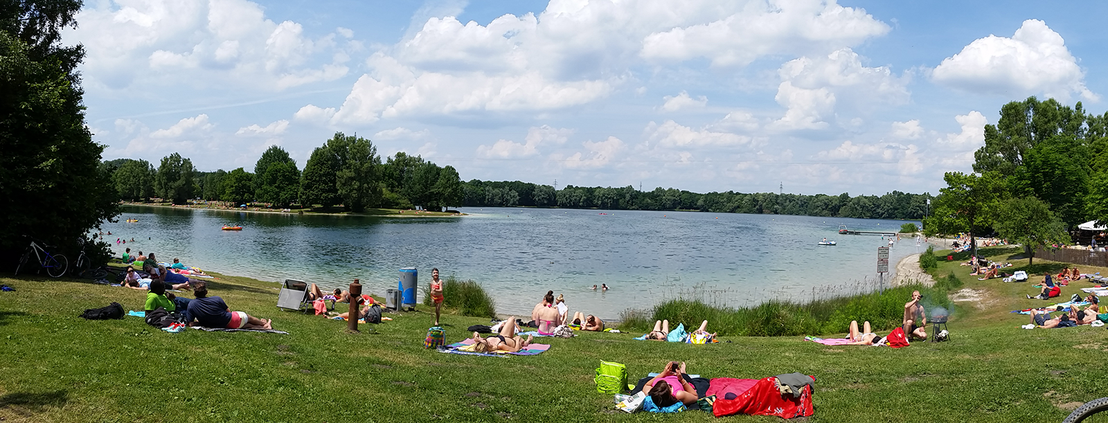 Feringasee near Unterföhring on a summer afternoon with grass, swimmers, and open lake water