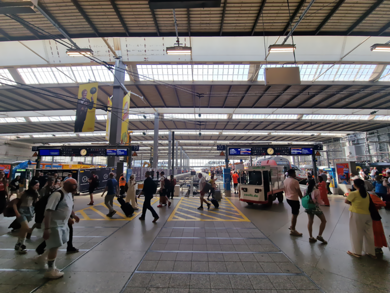 Munich Hauptbahnhof main hall with travelers pulling luggage across the platform concourse