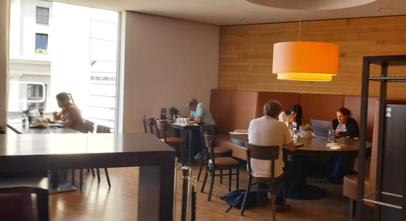 Indoor cafe seating at Oberpollinger in Munich with people using laptops