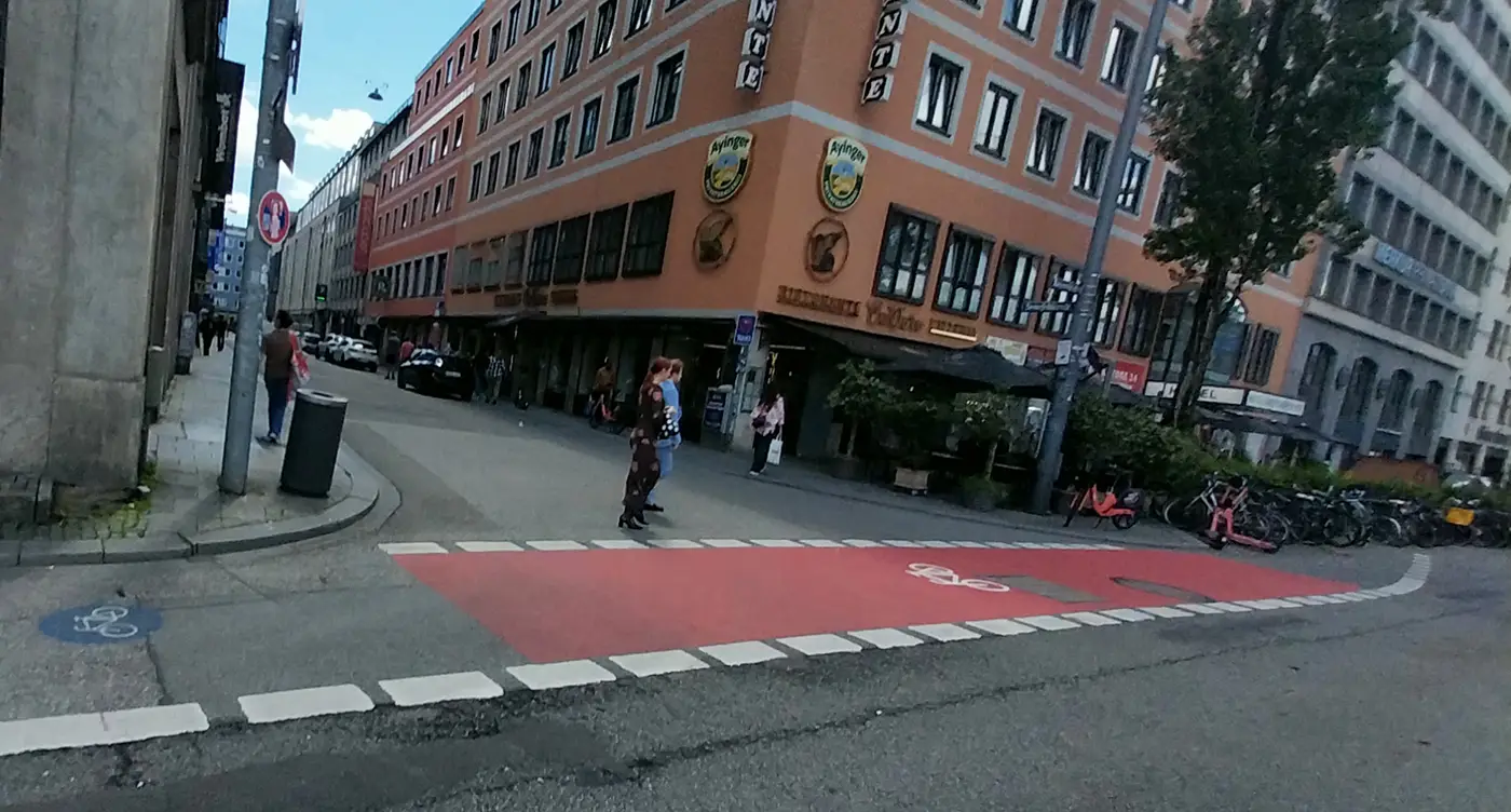Driving from Munich through a city intersection with a red bike lane