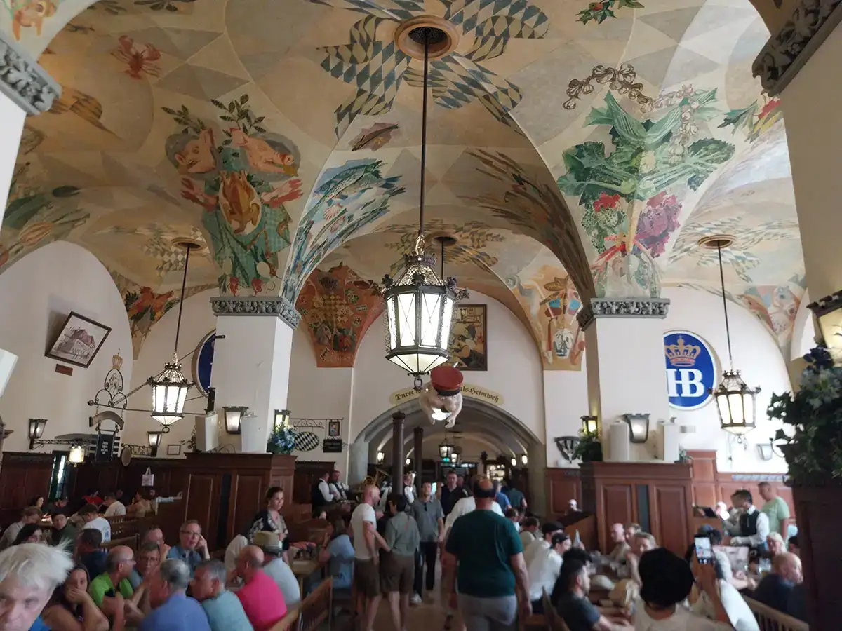 Hofbräuhaus beer hall interior in Munich with painted ceiling and long tables