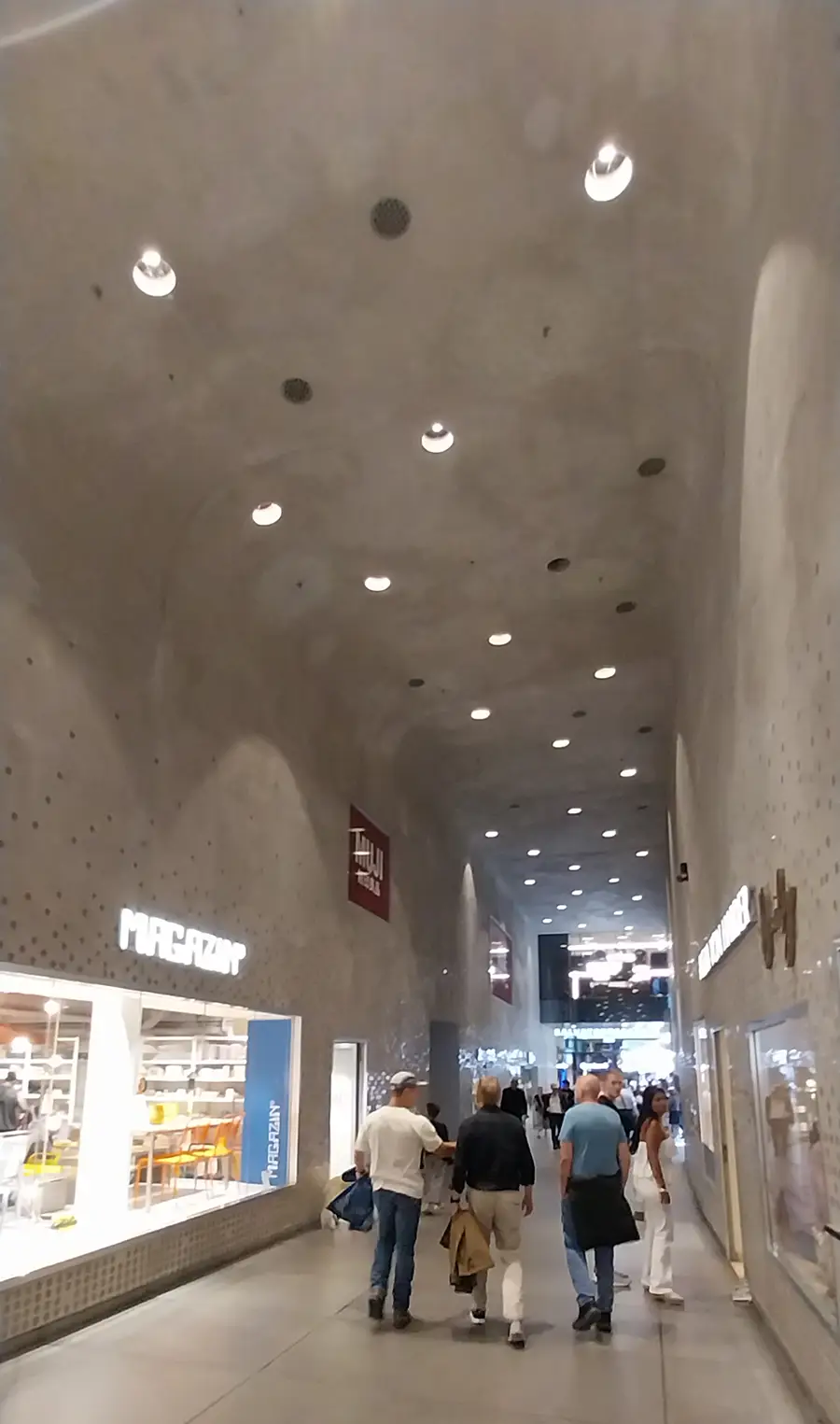 Interior passage of Fünf Höfe shopping arcade in Munich with shops and pedestrians
