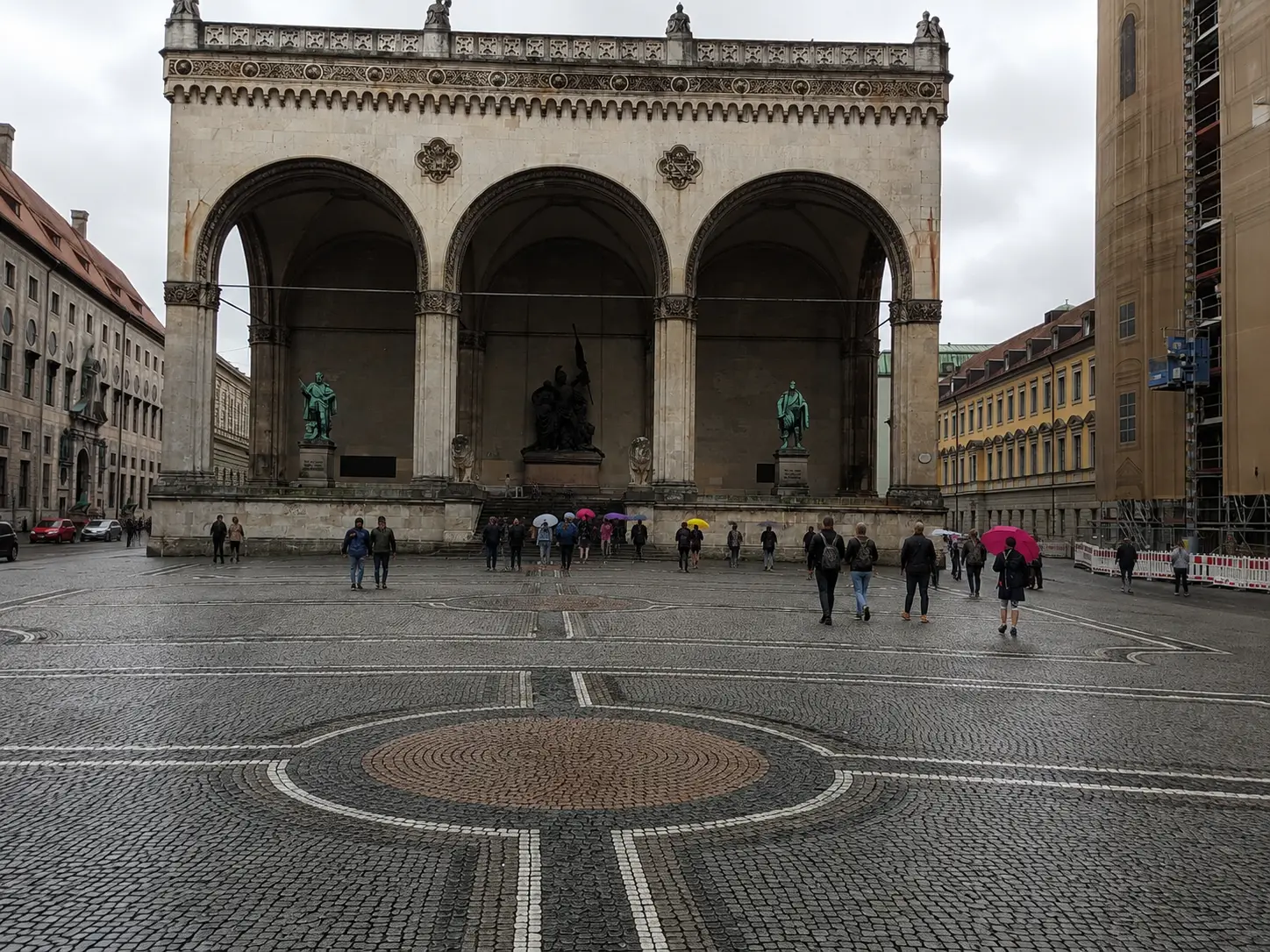 Rainy day near Odeonsplatz in Munich with umbrellas and wet pavement