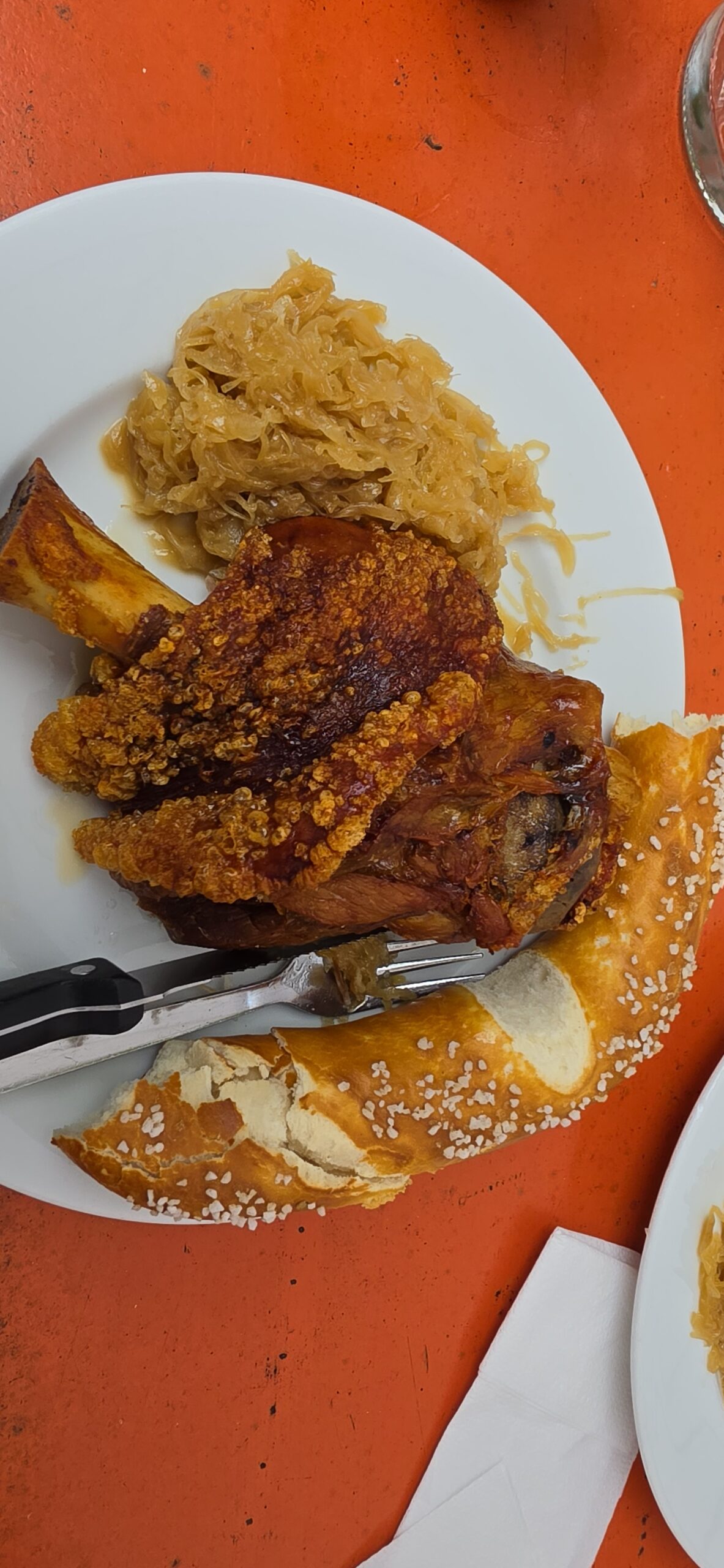 Roasted pork knuckle with sauerkraut and Brezn at a Munich beer garden