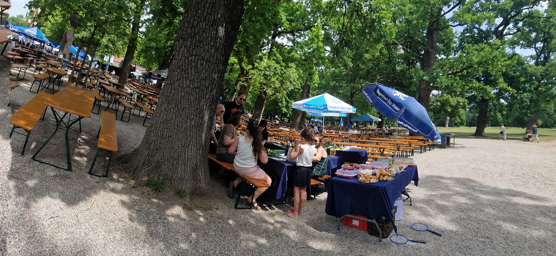 Family sharing food brought from home at Hirschgarten beer garden in Munich