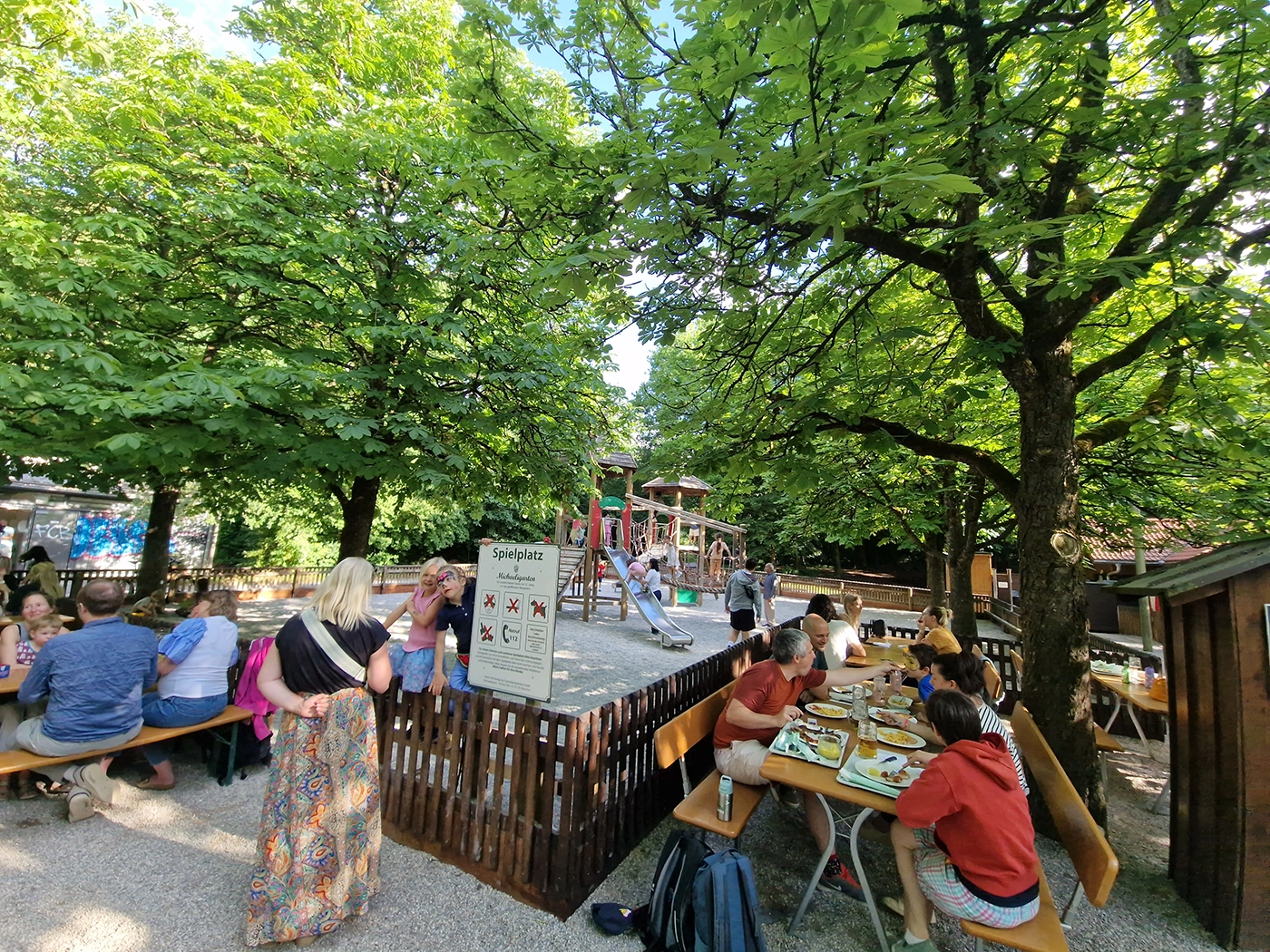 Fenced playground beside family tables at Michaeligarten beer garden in Munich