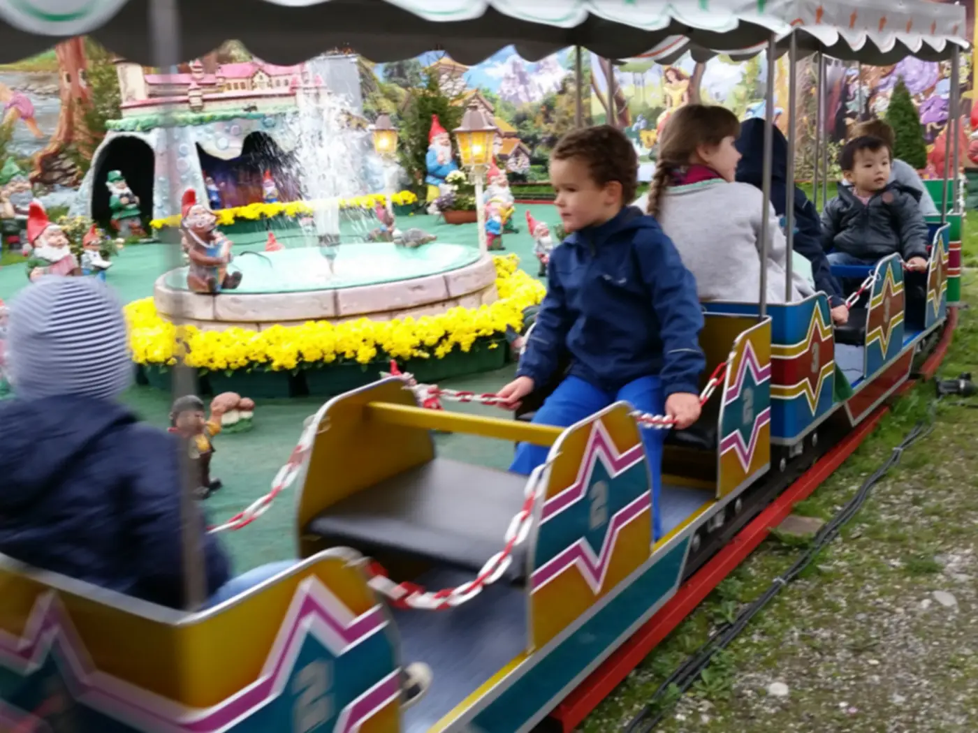 Children riding a small train at Oktoberfest in Munich during a daytime family visit