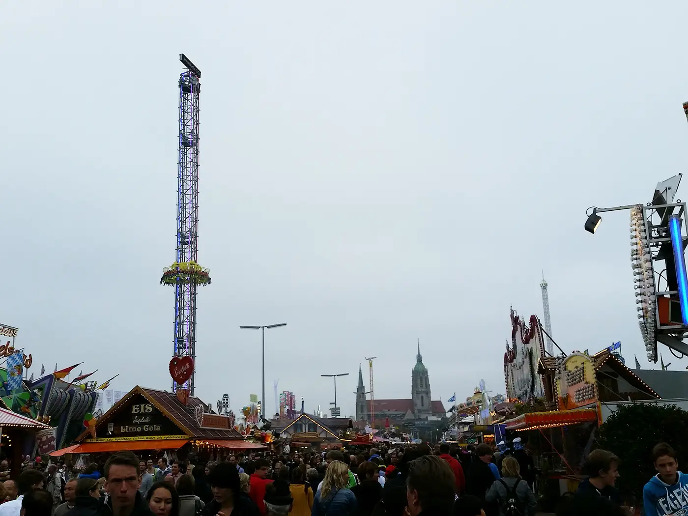 Oktoberfest grounds at Theresienwiese in Munich seen from above with beer tents, crowds, and fairground rides