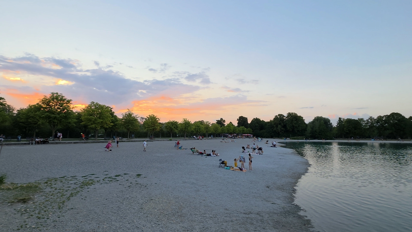 People relaxing by a lake on a warm summer evening in Munich