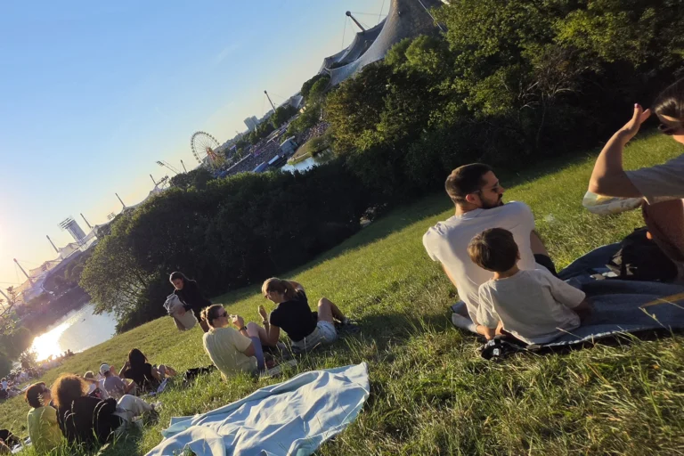 People relaxing on Olympiaberg during the 2026 Olympiapark Sommerfestival in Munich