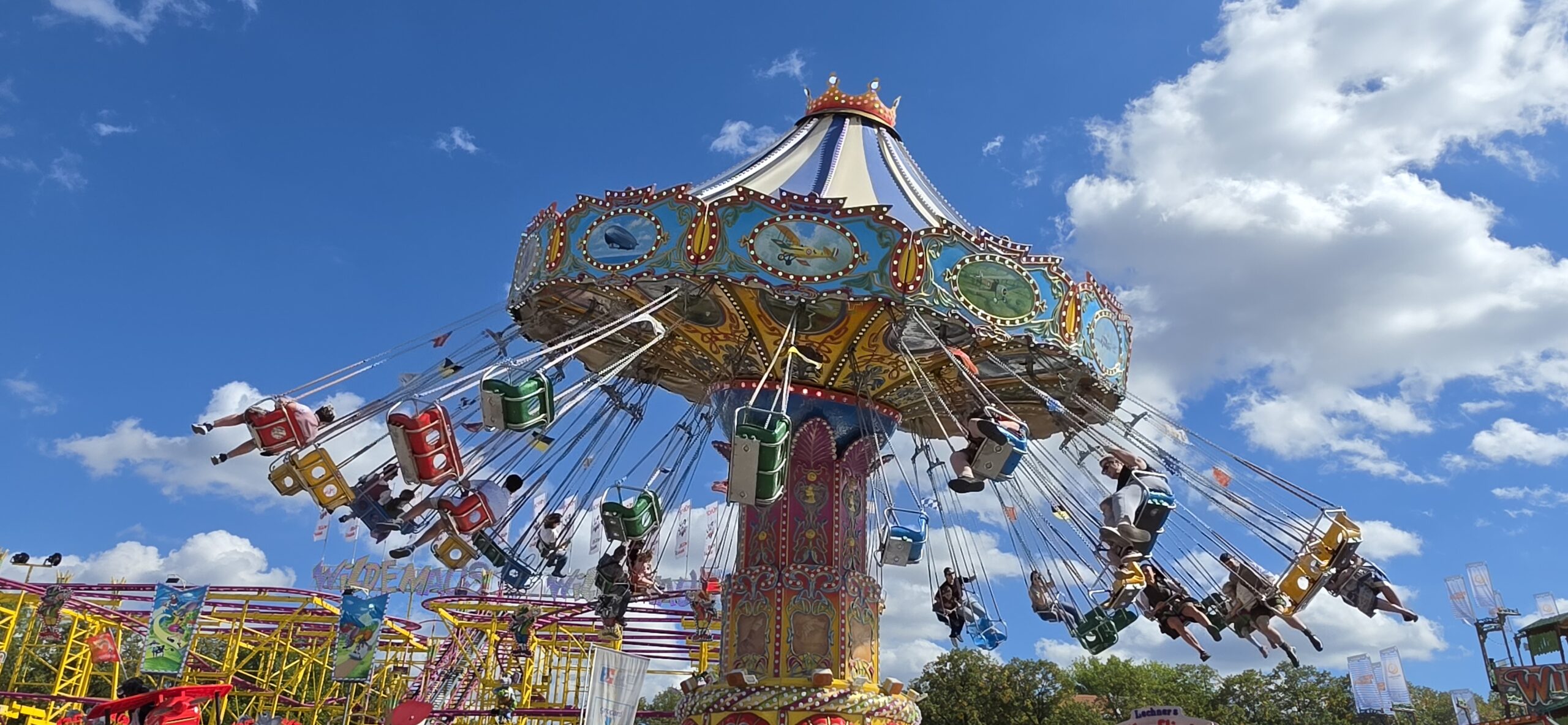 Colorful swing ride operating under a blue sky at Oktoberfest