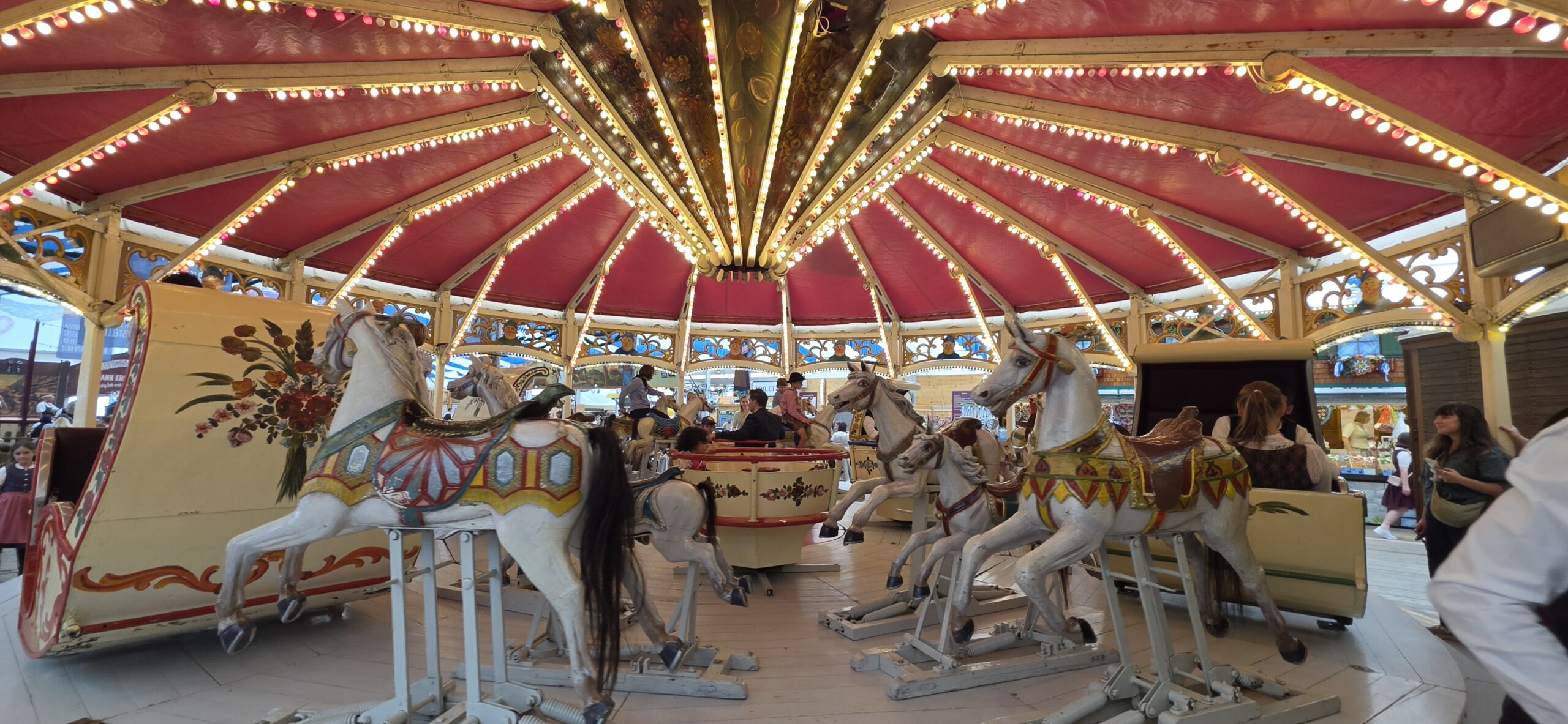 Historic carousel with painted horses at the Oide Wiesn